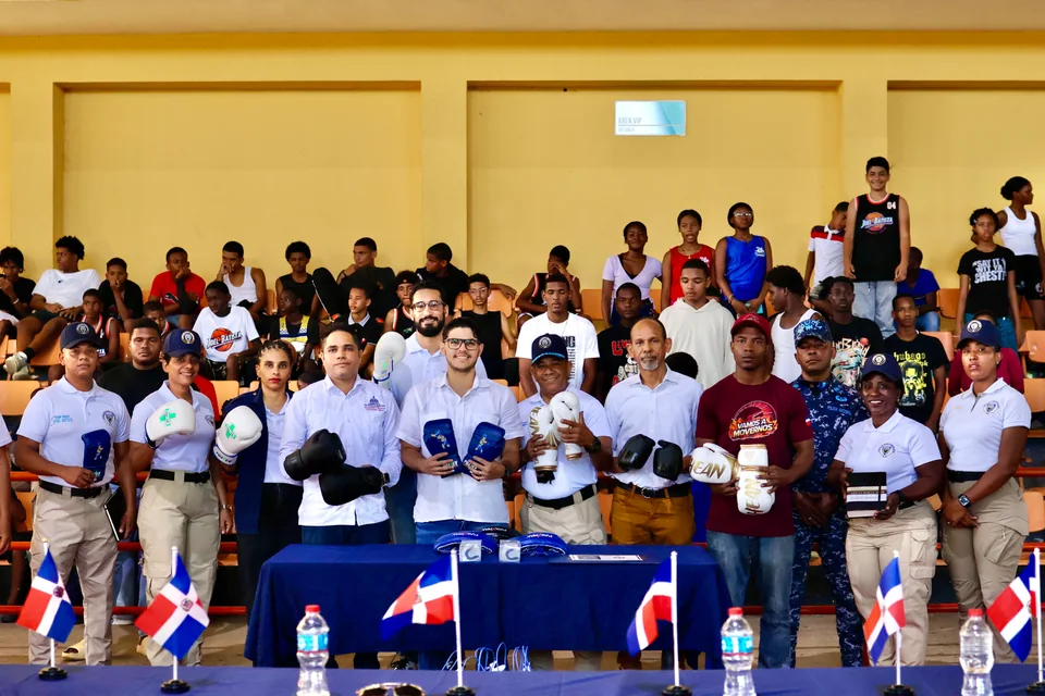 Representantes de la Fundación JCF, autoridades y atletas posan junto a la utilería de boxeo entregada durante la jornada “Elige la Cancha, No la Calle” en Monte Plata.